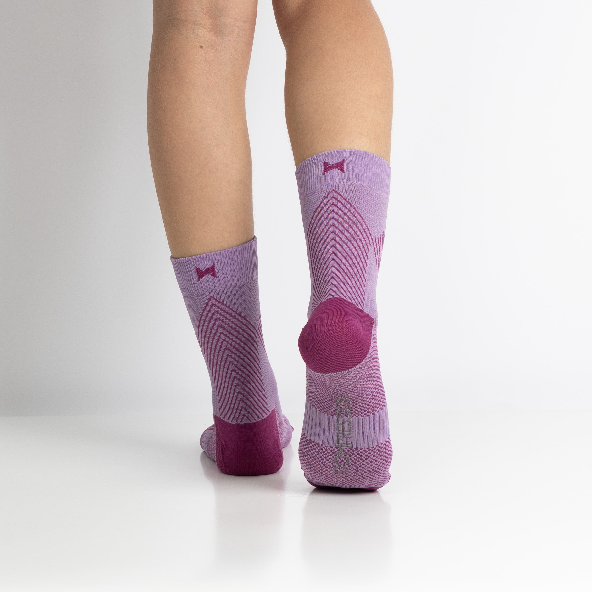 Meias de compressão de cano curto/médio para mulher, na cor rosa. Estas meias são indicadas para desporto, como corrida ou caminhada intensa, e ajudam no inchaço das pernas e pés, e na circulação do sangue.